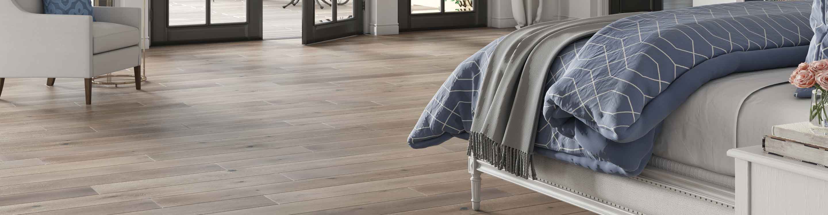 gray plank hardwood flooring in contemporary bedroom with purple duvet, double doors to balcony and fireplace